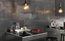 Restauracja z czarnymi płytkami na ścianie imitującymi metal Italgraniti Metaline Iron Melt