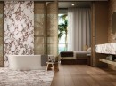 Sypialnia połączona z łazienką z białą wanną wolnostojącą, marmurowymi płytkami i brązowymi drewnopodobnymi na podłodze Porcelanosa Gent Roble Matt