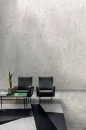 Pomieszczenie z fotelami wypoczynkowymi, płytkami imitującymi kamień, w kolorze szarym na podłodze Florim Architectural Design Plimatech Plimagray/01 Naturale/Matte i na ścianie Plimatech Plimawhite/01 Naturale/Matte