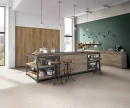 Kuchnia z czarno-drewnianą wyspą na środku, wiszącymi lampami, drewnianymi szafkami i płytkami podłogowymi Florim Contemporary Design Elemental Stone White Sandstone Naturale