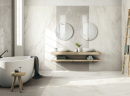 Elegancka łazienka z białą wanną wolnostojącą, lustrami, drewnianym blatem i umywalkami nablatowymi oraz płytkami imitującymi marmur Florim Contemporary Design Exalt Magic White i Silver Light