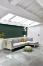 Aranżacja wnętrza na poddaszu, z jasną kanapą, zielonymi ścianami i płytkami podłogowymi imitującymi kamień Florim Contemporary Design Rock Salt Maui Green