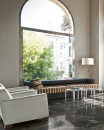 Salon z dużym oknem, białymi fotelami, czarną kanapą, stolikiem i płytkami podłogowymi imitującymi marmur Florim Contemporary Design Timeless Black Deep