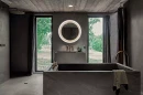 Łazienka z dużymi oknami, wanną wolnostojącą, deszczownicą, podświetlanym lustrem i szarymi płytkami imitującymi kamień Florim Contemporary Design Woodslate Life Storm