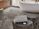 Łazienka z białą wanną wolnostojącą i płytkami podłogowymi imitującymi kamień Florim Creative Design Onyx&More Golden Porphyry