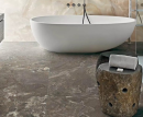 Łazienka z białą wanną wolnostojącą i płytkami podłogowymi imitującymi kamień Florim Creative Design Onyx&More Golden Porphyry