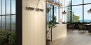 Lobby hotelowy wyłożone płytkami Barwolf California Warm Taupe KE-23022 12,4x12,4. Podłoga wyłożona przebarwianymi płytkami imitującymi drewno.