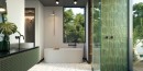 Łazienka z kabiną typu Walk-In, półokrągłą wanną wolnostojącą, zieloną podwieszaną szafką oraz płytkami Barwolf Loft Emerald Green Gloss KE-22109 6x25 wyklejonymi w kabinie.