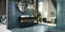 łazienka wyłożona niebieskimi płytkami Barwolf Loft Saphire Blue Gloss KE-22113 13,7x15. Kabina prysznicowa typu Walk-In. Czarna szafka łazienkowa i okrągłe lustro z czarną ramką.