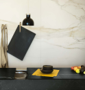 Czarna kuchnia z lampami wiszącymi, sprzętem i akcesoriami kuchennymi oraz płytkami na ścianie imitującymi marmur Florim Luxury Design I Classici Calacatta Gold