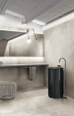 Łazienka z czarną umywalką wolnostojącą, srebrną baterią, podświetlanym lustrem i płytkami imitującymi kamień Florim Luxury Design Matières Sable