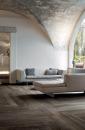 Salon z jasnymi kanapami, łukami na suficie i płytkami podłogowymi drewnopodobnymi Florim Luxury Design Planches Choco