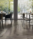 Restauracja z dużymi oknami, stolikami i płytkami podłogowymi drewnopodobnymi Florim Luxury Design Planches Perle