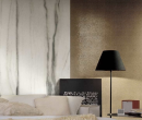 Salon z jasną kanapą, ozdobną ścianą ze złotą mozaiką i płytkami imitującymi marmur Florim Luxury Design Prexious White Fantasy