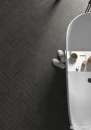 Podłoga łazienki wyłożona w jodełkę angielską płytką Equipe Stage Charcoal 6x30, półokrągła wanna wolnostojąca