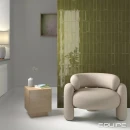 Salon wyłożony płytkami Equipe Island Frame Lichen 6,5x20 w wykończeniu strukturalnym i połysku, fotel skórzany w białym kolorze, szafka w kolorze jasnego drewna