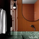 Łazienka z płytkami Equipe Vitral Caramel Reactive 5x40 wyklejonymi na ścianie, półokrągłe lustro z czarną ramą na ścianie, płytki połączone z zielonym lastryko