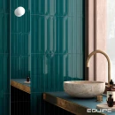 Ściana łazienki wyłożona płytkami Equipe Vitral Petrol Reactive 5x40, kamienna umywalka nablatowa i złota armatura