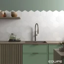 Heksagonalna płytka Equipe Coimbra White 17,5x20 wyłożona nad drewnianym blatem ze zlewozmywakiem,, zielone szafki kuchenne, czarna armatura kuchenna