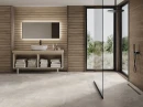 Łazienka z płytkami El Molino Toja Beige 40x120 które imitują drewniane lamele wyłożonymi na ścianach, kamienna podłoga, przeszklona kabina typu walk-in z czarnym obramowaniem