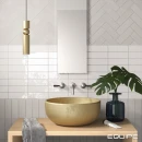 Ściana łazienki wyłożona płytkami Equipe Fango Blanc Gloss 5x15, podtynkowa trzyotworowa bateria umywalkowa, złota umywalka