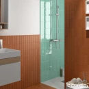 Gresowa, ścienna płytka Equipe Fango Aquamarine Gloss 5x15 wyłożona na ścianie kabiny prysznicowej z przeszkloną ścianą, białe meble łazienkowe, kwadratowe lustro