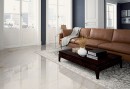 Salon w stylu glamour, z brązową skórzaną kanapą, czarnym stolikiem, ozdobnym dywanem i płytkami podłogowymi imitującymi marmur Alfalux Canova Arni