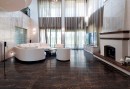 Salon w stylu glamour z długimi zasłonami, kominkiem, białą kanapą, białymi fotelami i brązowymi płytkami podłogowymi imitującymi marmur Alfalux Canova Collemandina