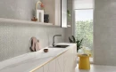 Kuchnia z marmurowym blatem, czarnym zlewem i baterią oraz płytkami na ścianie imitującymi beton Colorker Aston Pearl oraz z pofalowaną powierzchnią Colorker Aston Harwey Pearl