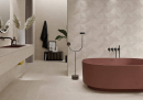 Łazienka w stylu taupe, z miedzianą wanną wolnostojącą, płytkami dekoracyjnymi na ścianie Colorker Oneida Beige oraz na ścianie, blacie i podłodze Colorker Hudson Beige imitujące kamień