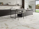 Kuchniaz podłogą wyłożoną płytkami STN Camile Gold Satin 60x60. Wyspa kuchenna z ciemnego drewna z jasnym blatem
