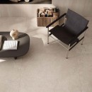 Aranżacja wnętrza z czarnym krzesłem, stolikiem i płytkami podłogowymi imitującymi kamień Flaviker Double Plain Beige Naturale