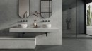 Otwarta łazienka w stylu loftowym wykończona płytkami producenta Italgraniti . Szara płytka strukturalna Liestone Grey Riga 60x120 na głównej ścianie łazienki. Czarna armatura podtynkowa, półokrągłe lustra nad białymi umywalkami wolnostojącymi