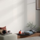 Wnętrze z drewnianą półką, fotelem wypoczynkowym i białą płytką na ścianie imitującą marmur Mirage Jewels Extrawhite JW19