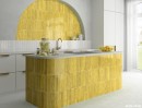 Hiszpańska żółta płytka cegiełka ceramiczna w połysku Equipe Menorca Lime 6,5x32,8 wyłożona na ścianie oraz obudowie wyspy kuchennej w połączeniu z białymi szafkami oraz jasną podłogą