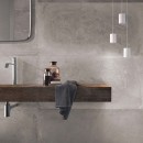 Łazienka z drewnianym blatem i szarymi płytkami na ścianie imitującymi beton Flaviker Backstage Ash Naturale