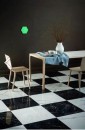 Drewniany stolik wraz z krzesłami stojący na białych oraz czarnych płytkach marmurowych Marazzi Allmarble Elegant Black R10B RT 60x60 MEWQ 60x60 cm