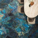 Emil Tele Di Marmo Lumia Labradorite Full Lappato 60x120 EN8A płytka podłogowa onyksowa w niebieskim kolorze na podłodze jadalni. Półokrągły stół z kamiennym beżowym blatem
