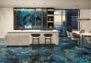 Emil Tele Di Marmo Lumia Labradorite Full Lappato 60x120 EN8A płytka podłogowa onyksowa w niebieskim kolorze wyłożone na podłodze oraz ścianie kuchni w połączeniu z jasnymi płytkami imitującymi kamień na ścianach oraz wyspie kuchennej