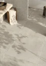 Włoska gresowa płytka imitująca beton Emil Ever-Stone Grey Naturale R10 100x100 EN5U w szarym kolorze na podłodze oraz ścianie otwartej łazienki.