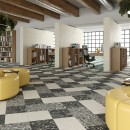 Wnętrze biblioteki ze stanowiskami oddzielonymi ściankami z jasnymi płytkami Arcana Spuma Sorbetto Panna oraz płytkami podłogowymi z efektem mieszania farby Arcana Spuma Panna, Chia oraz Sesamo