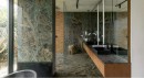 Designerska łazienka ozdobiona matowymi płytkami marmurowymi w zielonym kolorze Marazzi Allmarble Verde Borgogna Natural 60x120 MELH, z dużymi szklanymi oknami, czarną umywalką oraz armaturą oraz dużym, prostokątnym lustrem