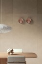 Wnętrze z beżowymi płytkami na ścianie imitującymi beton Fioranese Ogi Terra05 Naturale 90,6x90,6 OGI905R