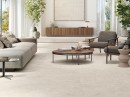 Salon z meblami wypoczynkowymi, drewnianym stolikiem kawowym, pytkami podłogowymi imitującymi beton, w kolorze beżowym Porcelanosa Cancun Caliza