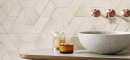 Łazienka z umywalką nablatową typu misa, miedzianą baterią podtynkową oraz  beżowymi, dekoracyjnymi płytkami na ścianie Porcelanosa Deco Terra Bone