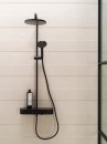 Czarna bateria prysznicowa i beżowe płytki ścienne imitujące beton Porcelanosa Terra Bone