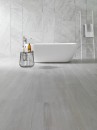 Łazienka z białą wanną wolnostojącą i szarymi płytkami marmuropodobnymi Porcelanosa Indic