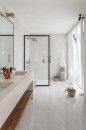 Przestronna łazienka z białą wanną, kabiną prysznicową ze szklanymi drzwiami i marmurowymi płytkami w białym kolorze na ścianie oraz podłodze, Marazzi Grande Marble Look Onice Avorio Lux