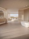 Beżowa otwarta łazienka połączona z sypialnią z drewnianą podłogą oraz płytkami ściennymi Porcelanosa Roma Marfil