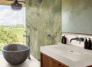 Nowoczesna łazienka z zielonymi płytkami Marazzi Grande Marble Look Onice Giada Lux imitującymi marmur, wanną z szarego betonu i umywalką z kolekcji Marazzi, które dopełniają aranżację